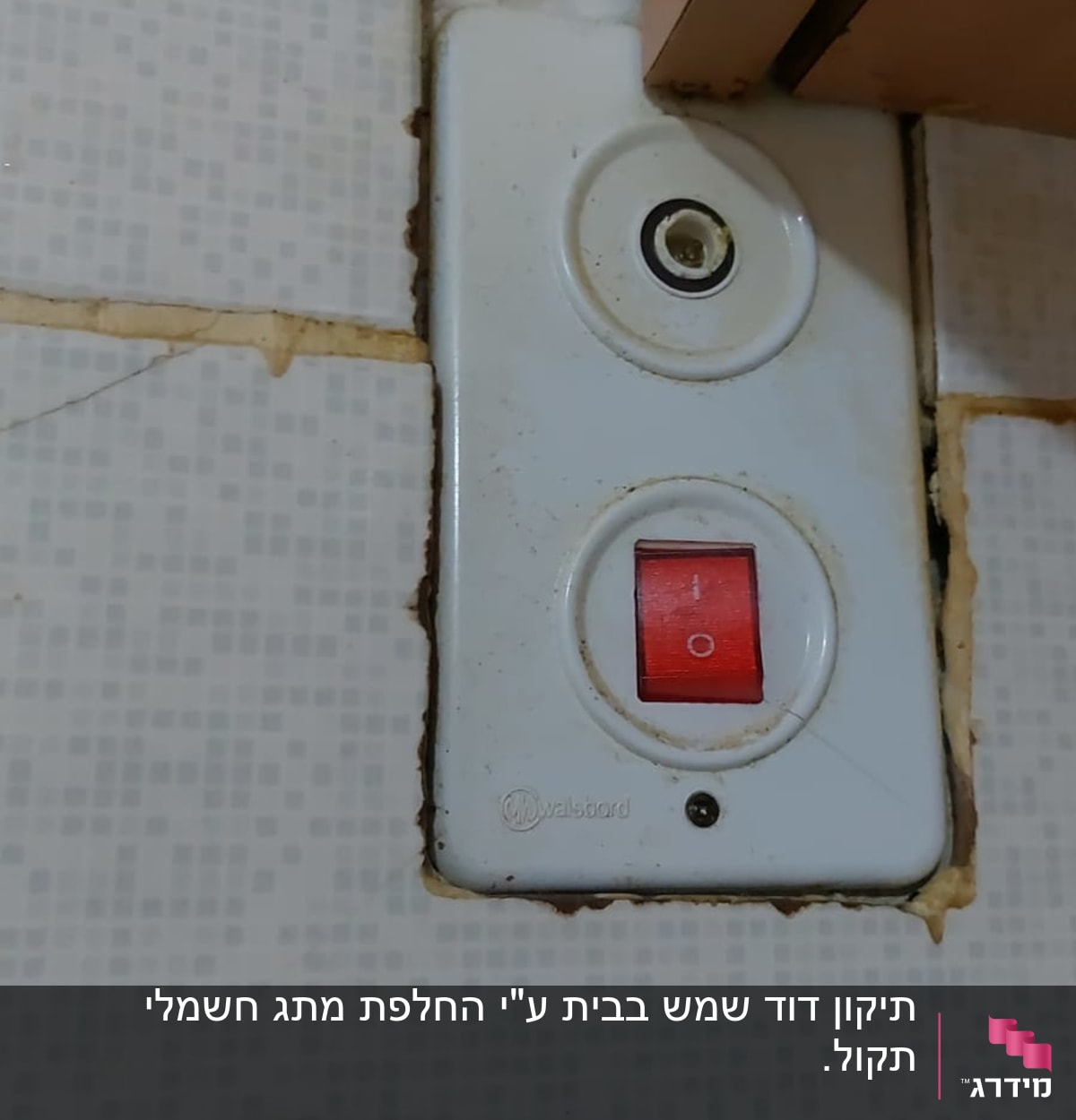 מתג חשמלי עם כפתור אדום על קיר